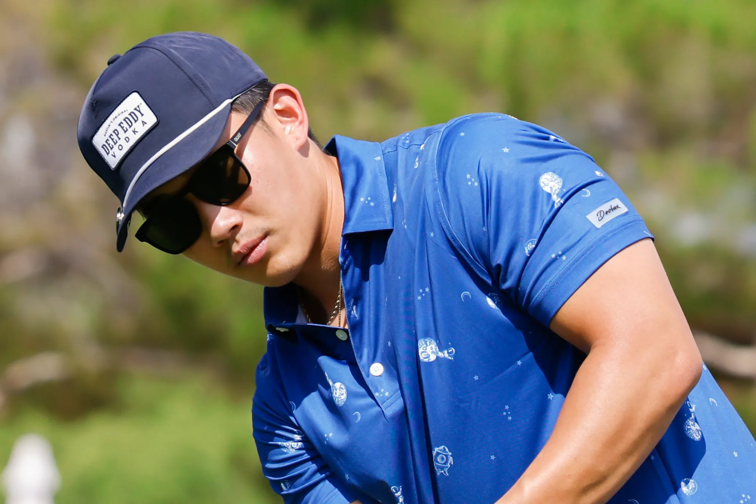 Golfer in blue navy hot air balloon pattern polo playing golf on a course