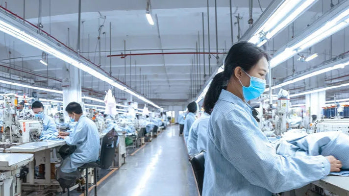 Garment assembly line workers sew garments carefully