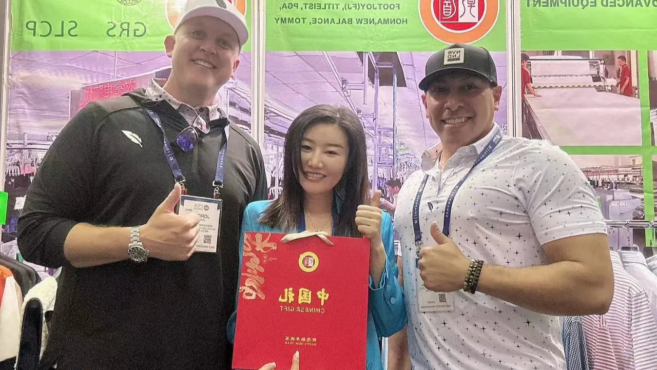 Qiandao's learder took a group photo with golfwear customers at an international clothing exhibition