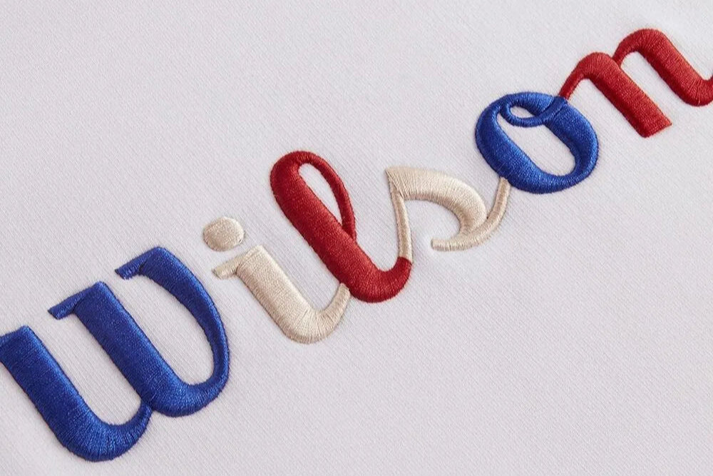 The logo embroidery on a white dress is exquisitely embroidered with three kinds of blue, red and white threads.