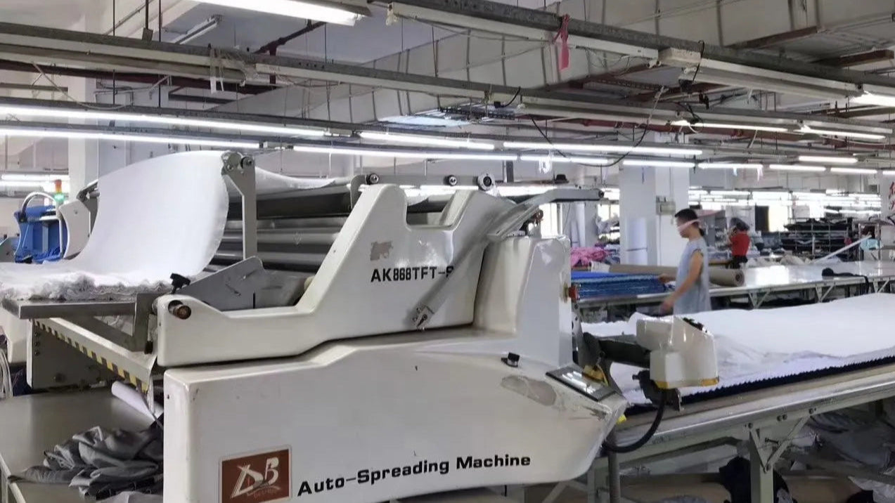 Qiandao apparel factory started from 2004, setting with an auto-spreading machine in a textile production line.